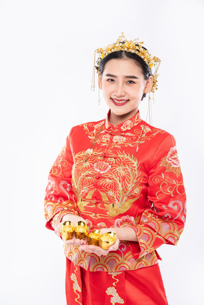 黄金穿旗袍西服的女人在中国新年里给家人送去黄金 祝他们好运中国新年微笑文化