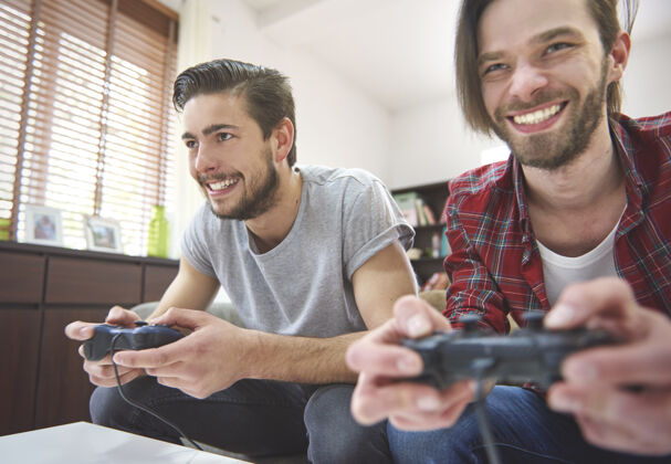 休闲游戏竞争在电视机前的朋友之间沙发友谊游戏