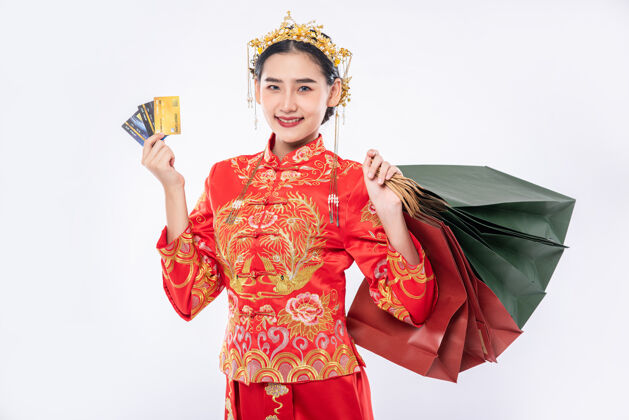 微笑女人穿旗袍套装开心用信用卡购物在中国传统节日文化信用卡金钱