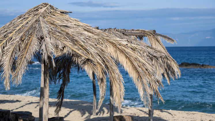 地中海爱琴海的海滩上用棕榈枝做成的雨伞 在希腊五颜六色海滩雨伞