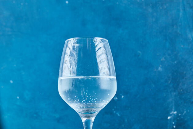 碳一杯蓝色表面的起泡水冷的饮料湿的