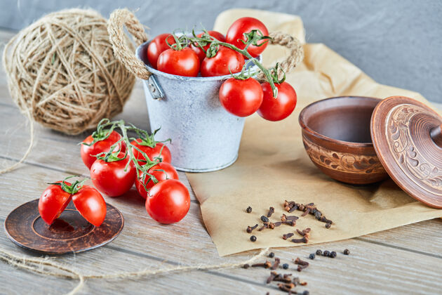 营养木桌上放着一桶西红柿和半切的西红柿羊毛碗线