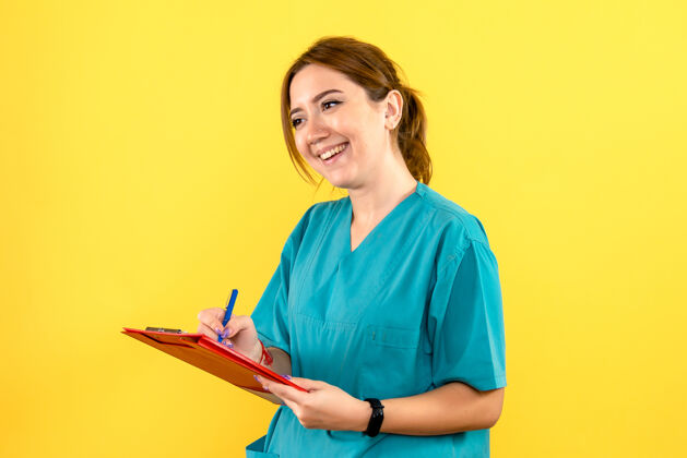 女兽医女兽医在黄色墙上写笔记的正面图肖像人快乐