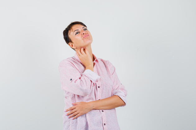 疾病穿着粉色衬衫的女性搔着脖子 神情犹豫不决 俯视前方犹豫呼吸女人