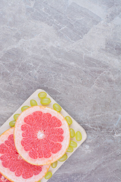健康柚子片和青葡萄放在木板上柑橘水果美味