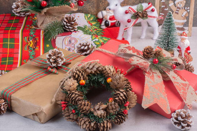 冬青果圣诞花环与礼品盒在白色表面树枝装饰松树