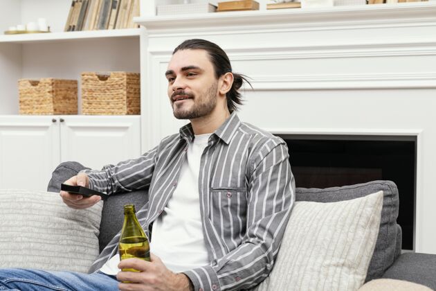 休闲喝啤酒看电视的男人生活方式早晨室内