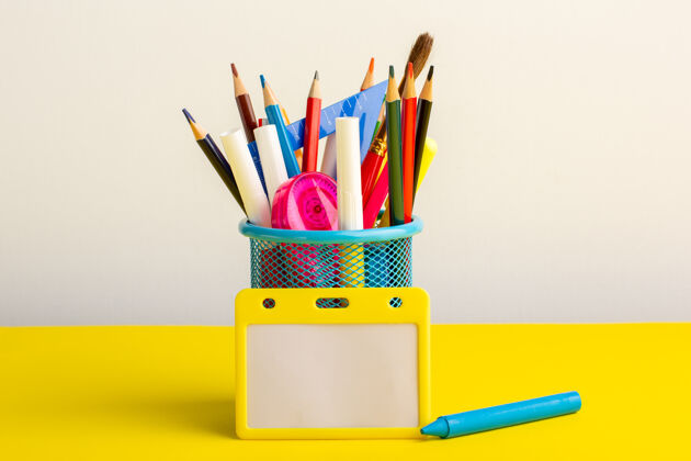 铅笔黄色书桌上有彩色铅笔和毛毡笔不同正面教育