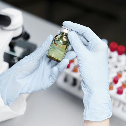 开拓者高角度的女研究员在实验室用疫苗瓶女人知识分子瓶子