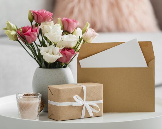 美丽在包装好的礼物和信封旁边的花瓶里放着一束玫瑰开花春天植物