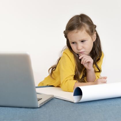 笔记本电脑小女孩用调色板和笔记本电脑画画广场科技女孩