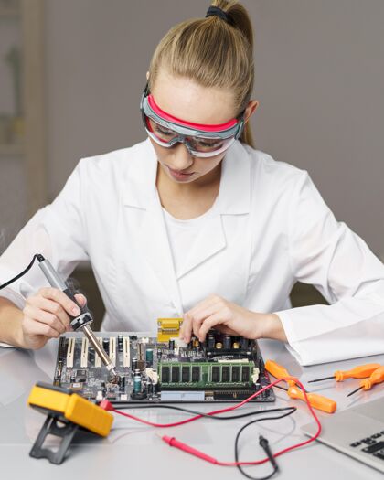 实验室女技师带烙铁和电子板的前视图专家开拓者研究