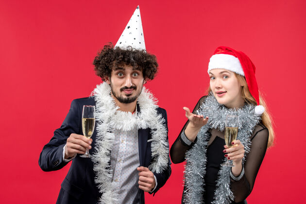 快乐正面图年轻夫妇在红墙欢庆新年爱圣诞派对年轻夫妇微笑服装
