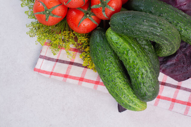 有机新鲜黄瓜 西红柿和罗勒放在桌布上食用绿色桌布
