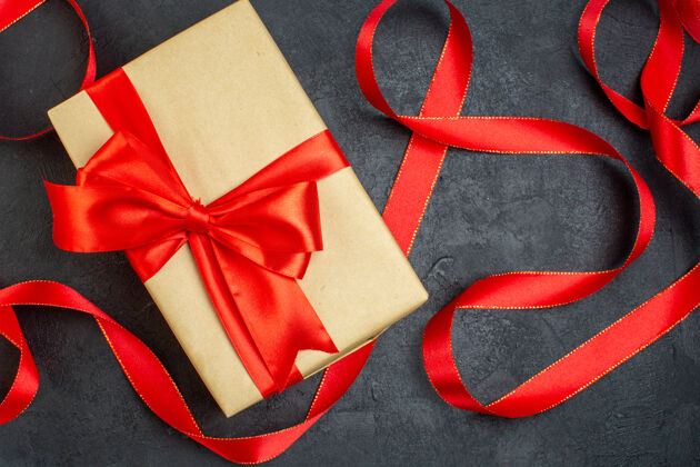 包装在黑暗的背景下 红色丝带叠成一堆美丽的礼物领带蝴蝶结购物