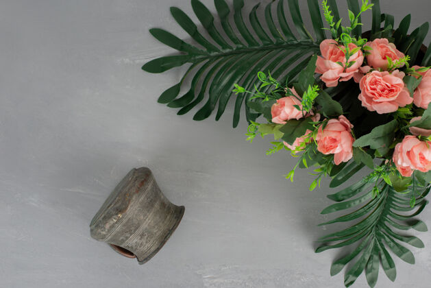 玫瑰一束粉红色的玫瑰 叶子和花瓶放在灰色的表面上开花花瓶五颜六色