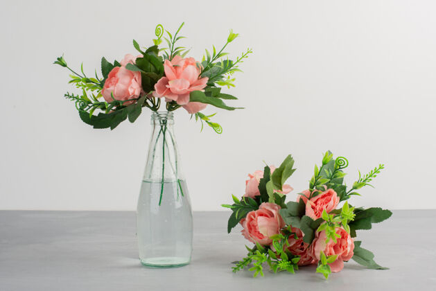 花瓶玻璃花瓶里有粉红色的花 灰色桌子上有一束花花束花花瓣