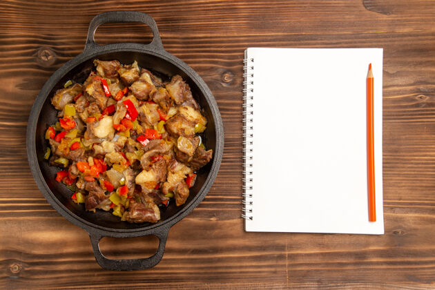 桌子顶视图熟肉蔬菜餐和木制桌上的记事本蔬菜盘子豆类
