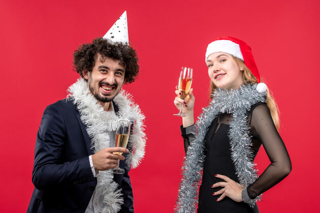 圣诞节前视图年轻幸福的夫妇庆祝新年在红地板假日圣诞爱情肖像羽毛宝儿围巾
