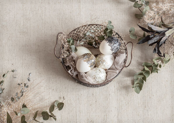 传统漂亮的复活节彩蛋放在一个用干花装饰的篮子里复活节快乐彩蛋干花符号