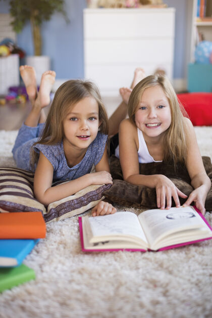 腿向上最喜欢的书在地板上读女孩向上指向