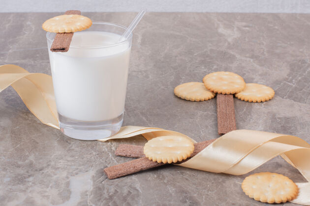 牛奶大理石桌上放着一杯牛奶 饼干和丝带盐饼干脆