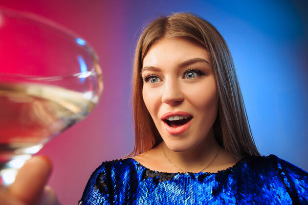 年轻一个穿着派对服的年轻女子拿着一杯酒摆姿势情感杯子金发