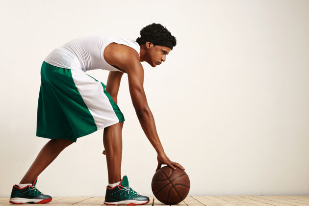 动作一个篮球运动员在白色的背拍照片拿着球在他的身边运动员看现代