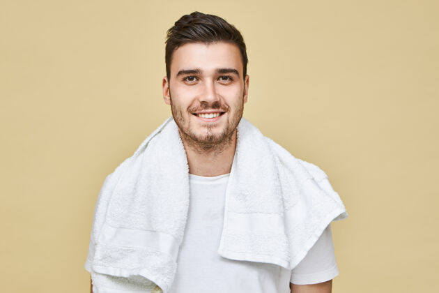 淋浴迷人开朗的欧洲年轻男性 留着胡茬 脖子上围着白毛巾 笑容满面 早上上班前要去洗手间刮胡子男孩身体新鲜