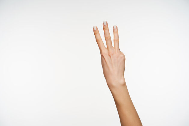 信号剪短的肖像 女人的手和白色指甲保持三个手指抬起 同时显示计数的手势 被隔离在白色手指身体站立