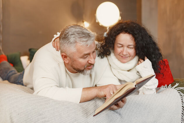 书年龄和人的概念家里的老年夫妇穿着白色针织毛衣的女人床编织老人