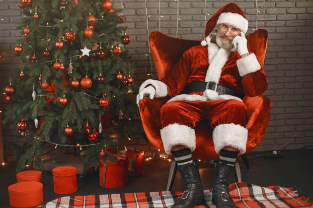 坐着圣诞老人在圣诞树旁休息家装老年人男性圣诞老人