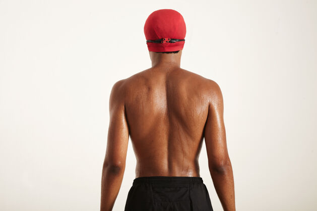 人湿背和头的年轻肌肉非洲裔美国游泳运动员在红帽子姿势运动员游泳