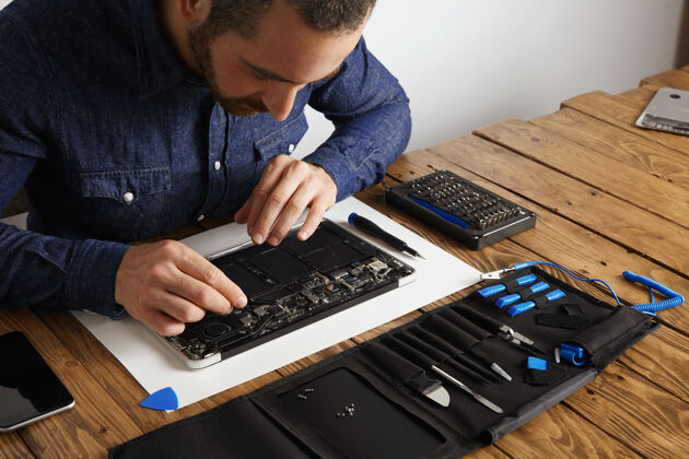 技术师父用有角度的esd镊子去除破损的超薄电脑笔记本电脑电子板上的灰尘 以修复它 让它重新工作组装技术组件