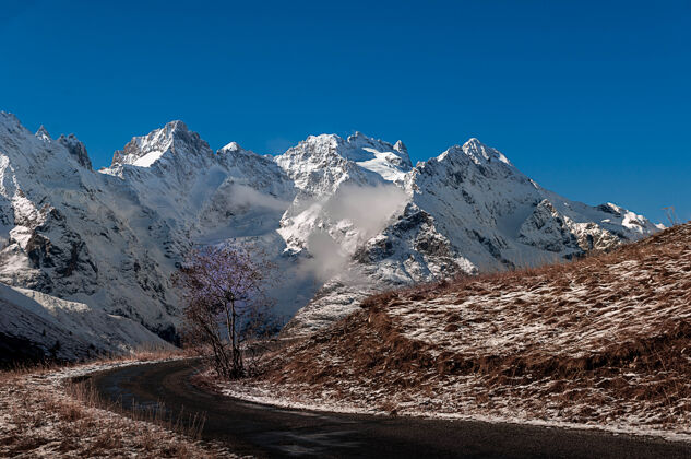 岩石雪山蓝天上的法国维拉尔-德阿雷内风景环境法国季节