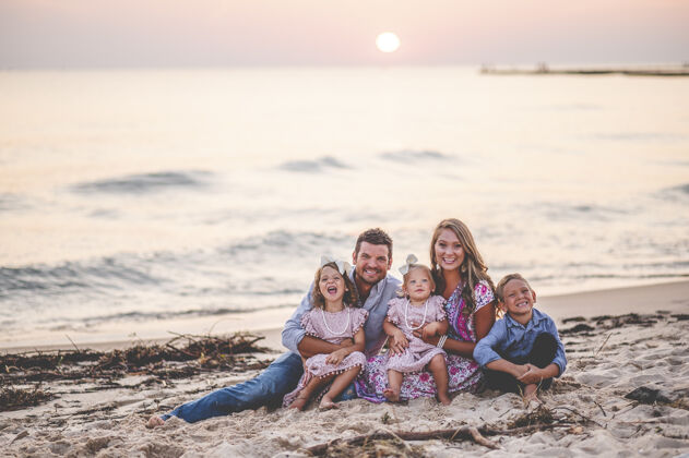 爱一个幸福的家庭坐在海边日落特写镜头-家庭概念男人海滩父母