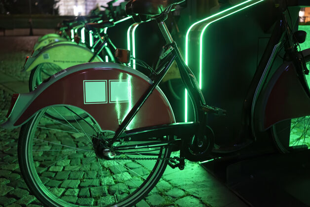 车站在罗马尼亚布加勒斯特的夜晚 停放自行车与绿色照明共享经典社区娱乐