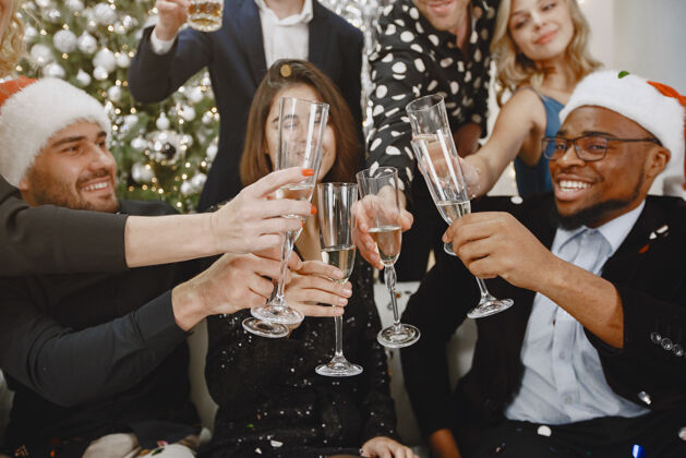 魅力一群年轻人庆祝新年朋友们喝香槟夜晚夏娃酒杯