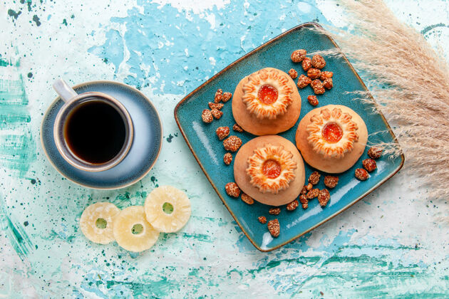 顶部俯瞰美味的蛋糕与饼干咖啡和甜坚果浅蓝色表面烤饼干蛋糕甜糖坚果蛋糕营养品饼干