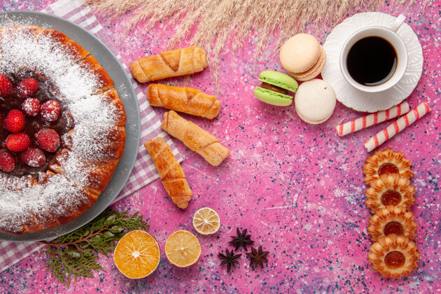 饼干顶视图美味的草莓蛋糕糖粉加上一杯茶法国马卡龙和百吉饼放在粉红色的桌上蛋糕甜饼干糖饼干草莓生的桌子
