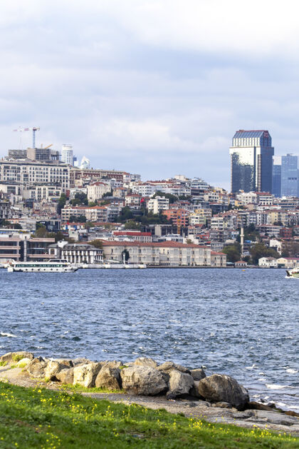 角伊斯坦布尔的一个住宅区和现代化的高层建筑 博斯普鲁斯海峡的船只 人们在岸边休息 土耳其船城市景观欧罗巴