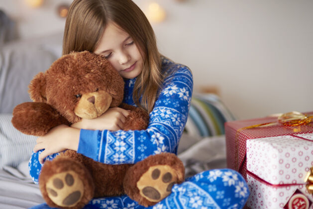 泰迪小女孩在圣诞节和泰迪熊玩床小女孩悲伤