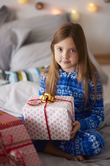 家里床上放着圣诞礼物的漂亮女孩盘腿早晨圣诞装饰