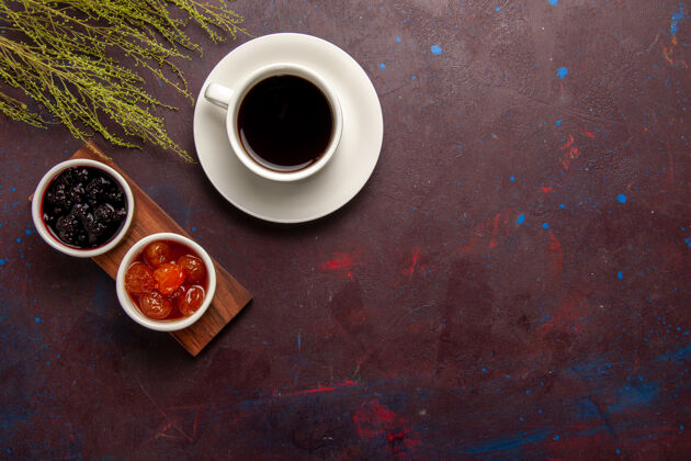 果酱顶视图咖啡杯上不同果酱的深色办公桌果酱果酱果酱甜茶不同的茶碟