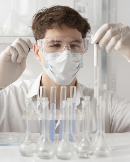 技术戴着护目镜和面具的男人安排化学研究