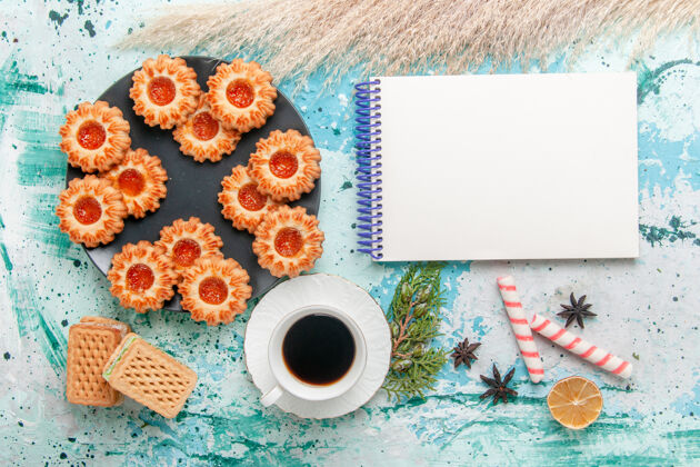 饼干俯瞰美味的小饼干与华夫饼和咖啡杯上的蓝色办公桌饼干饼干甜甜的糖色茶茶碟茶小