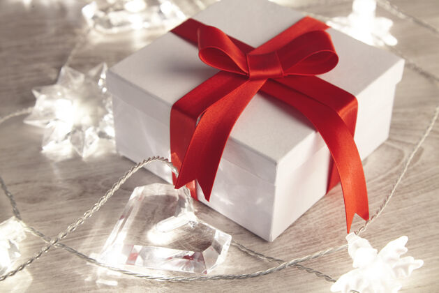 礼物漂亮简单的空白礼盒 用红丝带捆扎 周围有闪光灯浪漫可爱的礼物 送给圣瓦伦丁 节日 生日最小白色红色