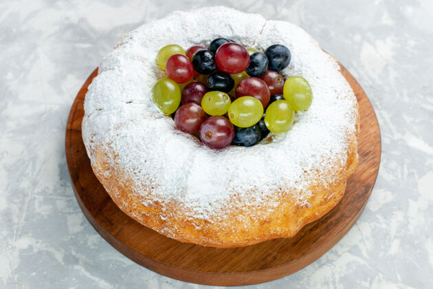 甜点正面近距离观看糖粉蛋糕美味的烤蛋糕 白桌上有新鲜葡萄 水果烤蛋糕 饼干糖甜葡萄桌子水果