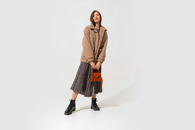 现代怀纳时尚外观时尚的浅棕色模型在米色皮毛大衣和全长全套好看长度