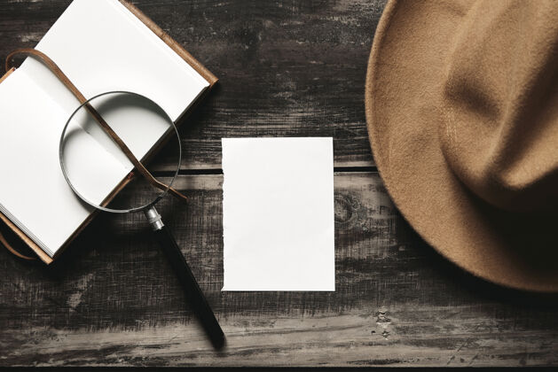 叉子神秘的侦探游戏概念打开皮套的笔记本 一张白纸 一顶棕色的毡帽和一个老式的放大镜黑色的老木桌上孤立的钢镜顶视图智能手机电话工艺